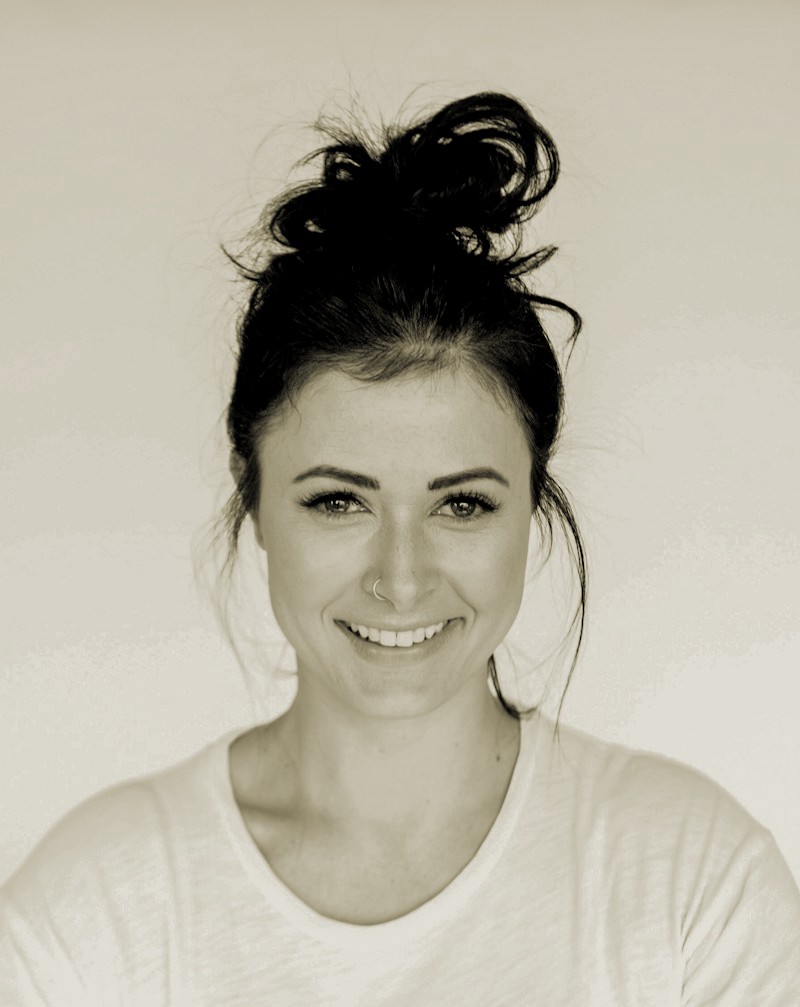 Portrait of a person in a pink sweater against a light background